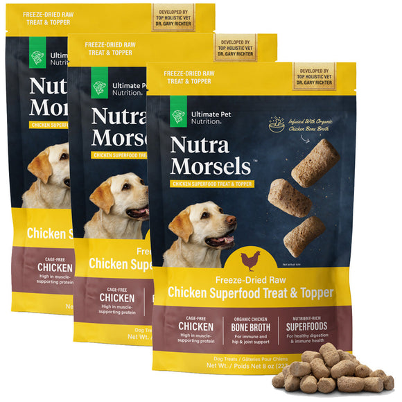 Three packages of Nutra Morsels freeze-dried raw chicken superfood treat and topper with a small pile of treats in front.